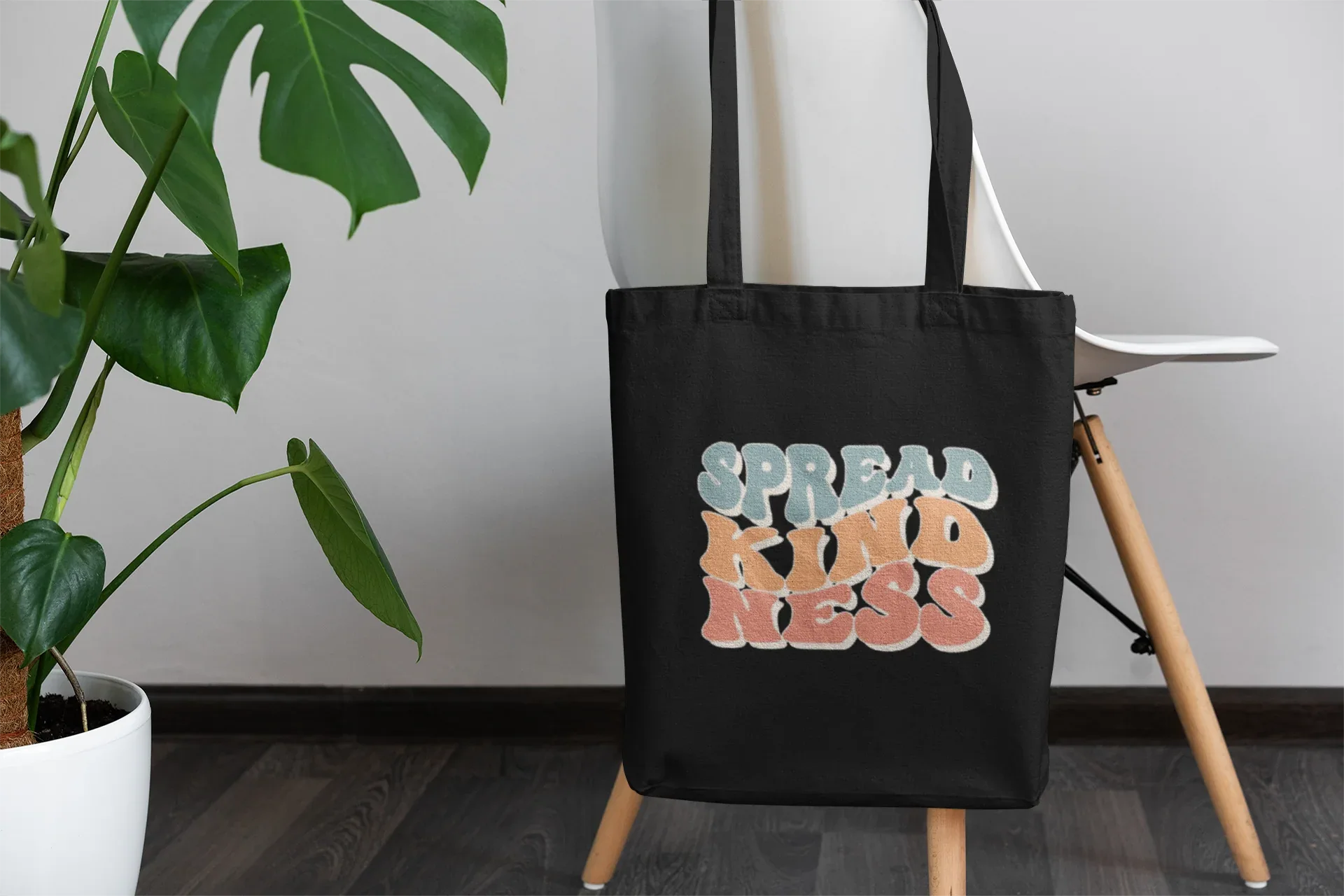Black cotton tote bag with 'SPREAD KINDNESS' graphic, front view