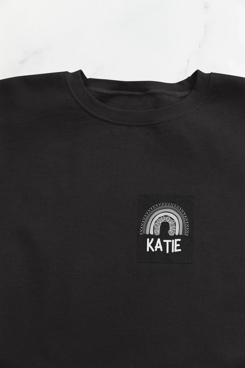 Black sweatshirt with square KATIE logo and arch design