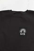 Black sweatshirt with square KATIE logo and arch design