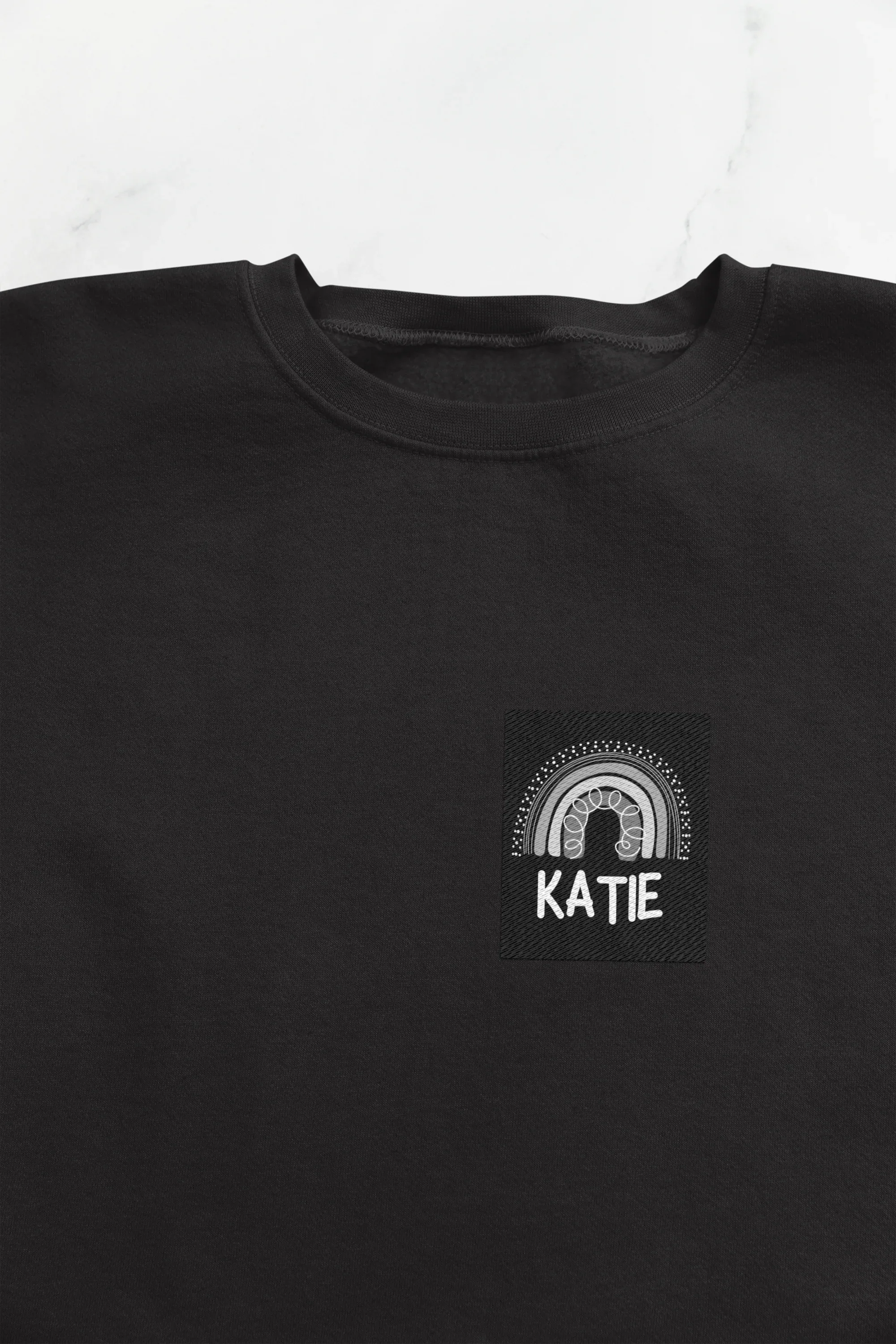 Black sweatshirt with square KATIE logo and arch design