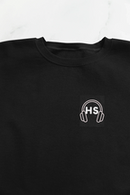 Black sweatshirt close-up: embroidered headphone logo on chest