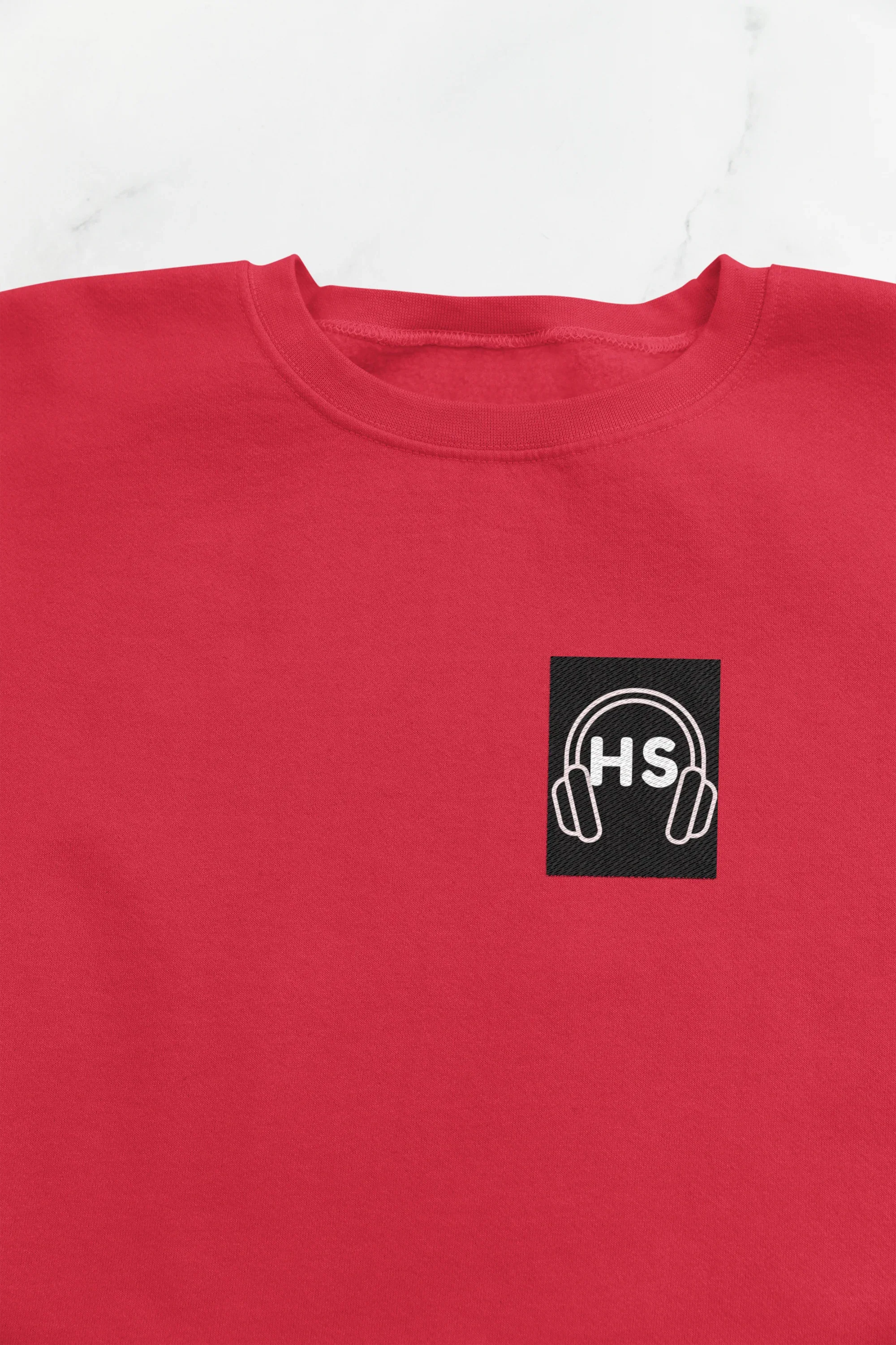 Red sweatshirt close-up with embroidered headphone logo on chest