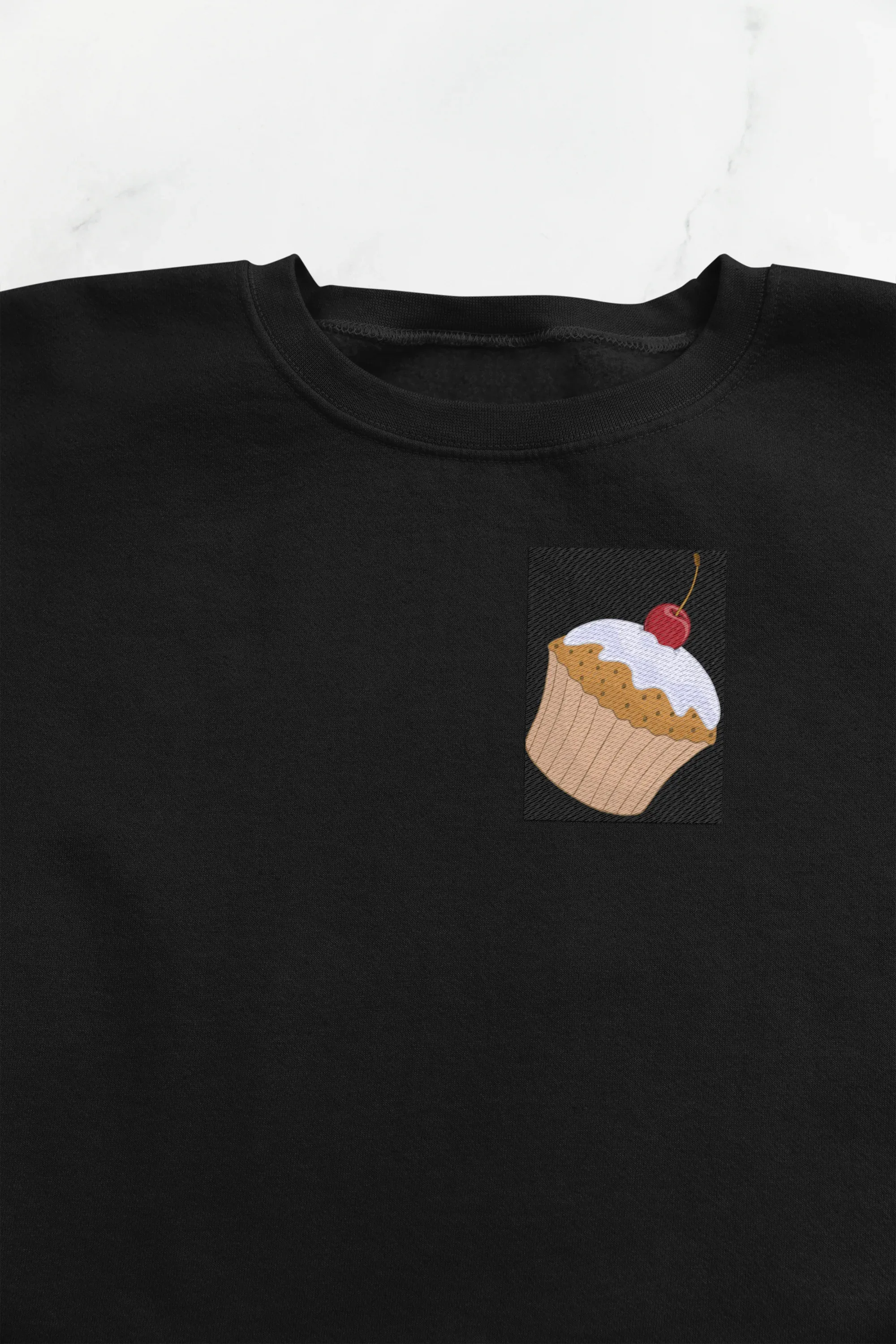 Black crewneck cupcake sweatshirt with small cupcake graphic patch on chest