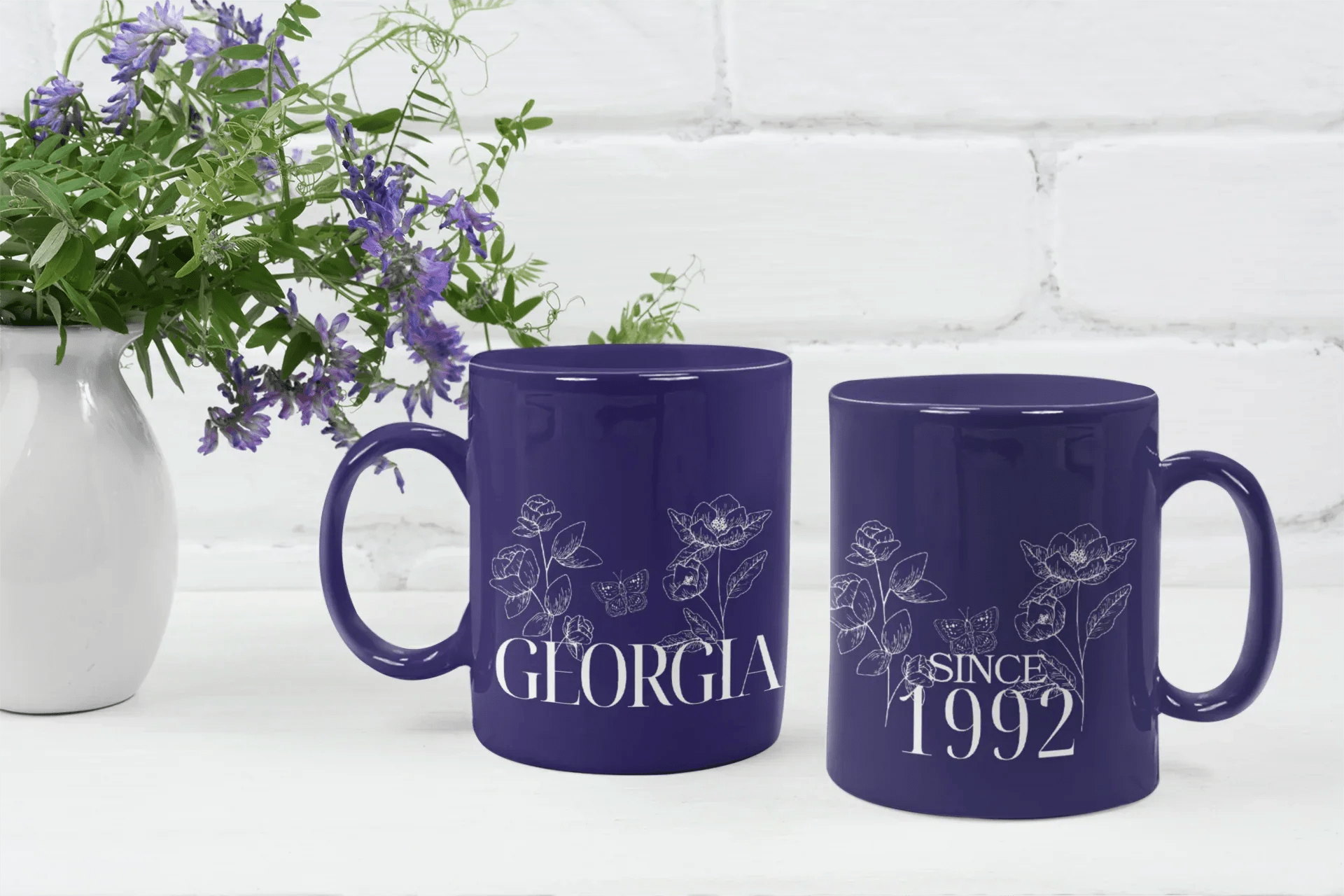 Set of two purple ceramic mugs with floral line art, “GLORIA” and “SINCE 1992”