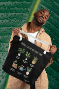 Black tote bag with white handles, plant graphic and 'THINGS I DO IN MY SPARE TIME'.