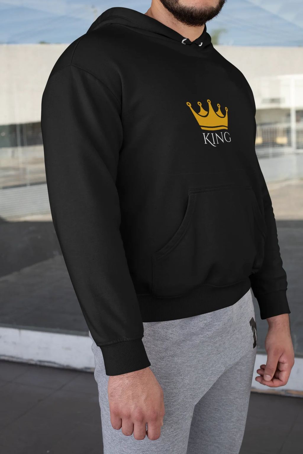 Black hooded sweatshirt with KING crown graphic on chest, worn with sleeves down