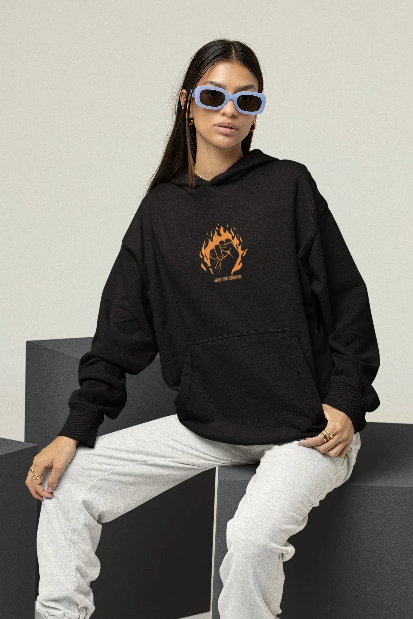 Black hooded sweatshirt with front pocket and orange flame face logo on chest