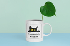 White mug with black cat and yellow eyes, 'Be careful, hot tea!' next to green leaf