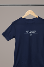 Navy blue T-shirt front on a wooden hanger with “KEEP CALM IT’S MY BIRTHDAY” text.