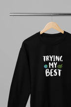 Black crewneck sweatshirt with "Trying My Best" text graphic on the front