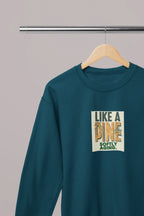 Teal sweatshirt with long sleeves and “Like a Pine” square logo on the chest