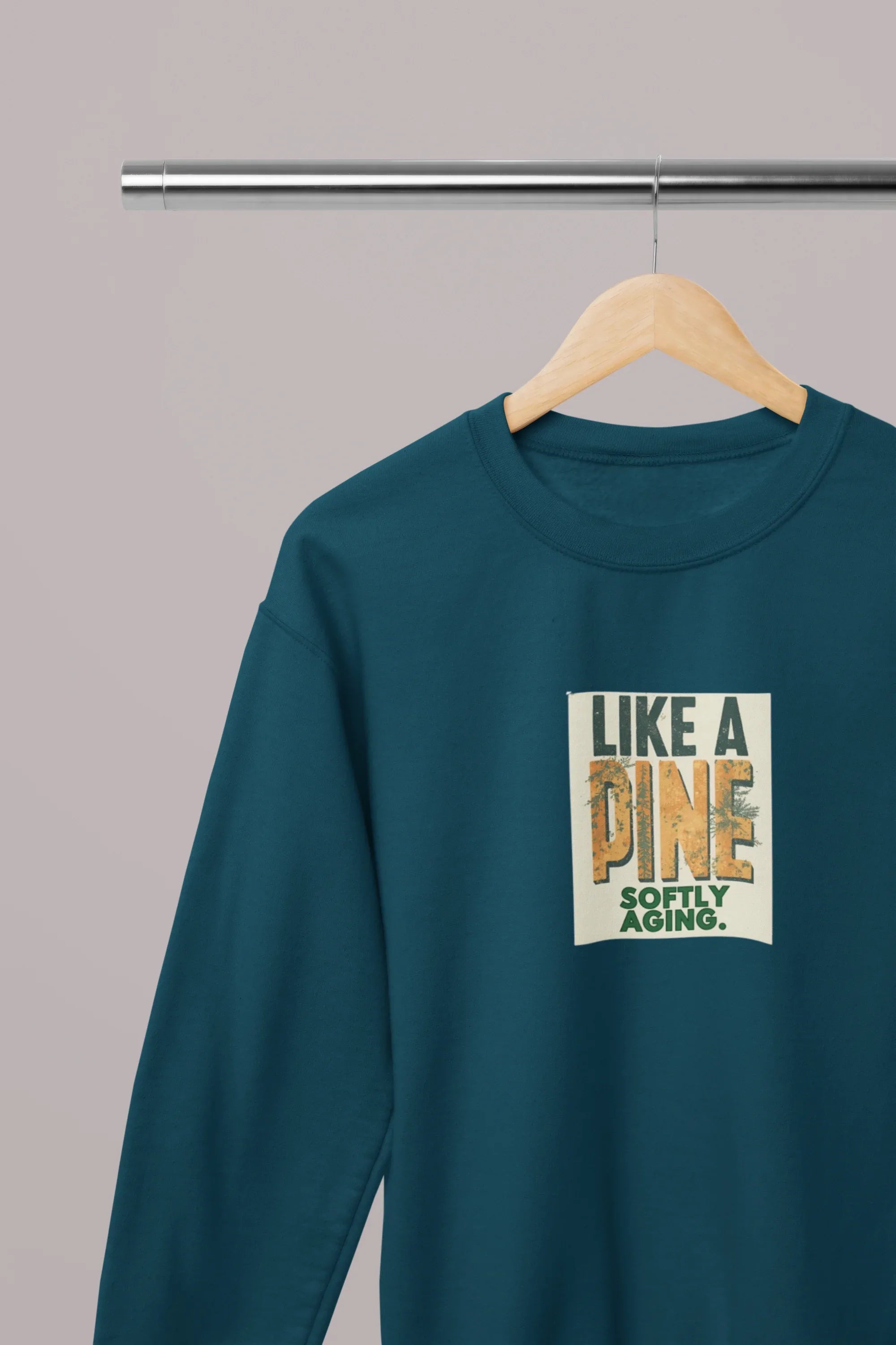 Teal sweatshirt with long sleeves and “Like a Pine” square logo on the chest