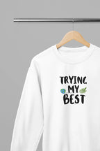 White crewneck sweatshirt with "Trying My Best" text graphic on the front