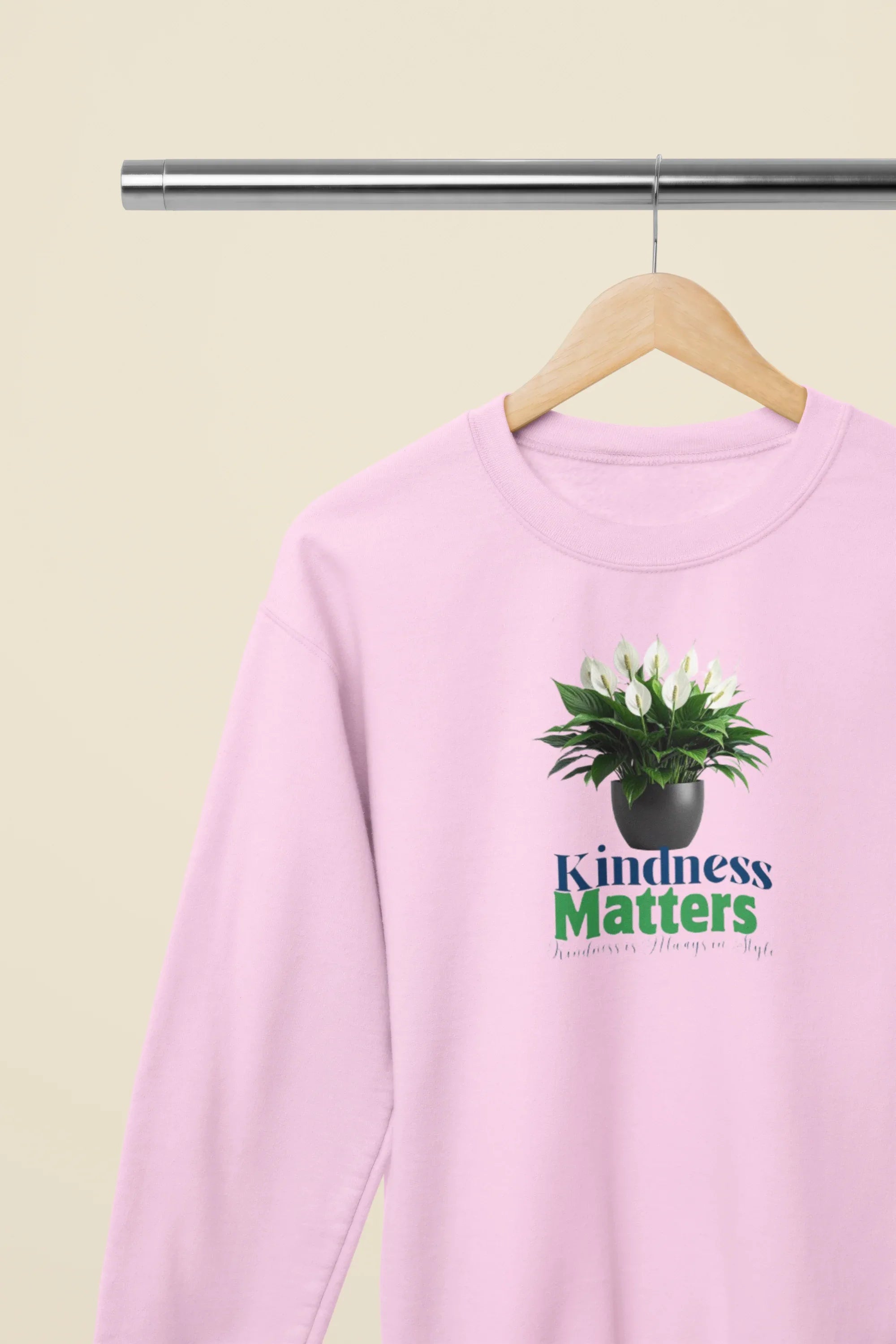 Light pink crewneck sweatshirt with tree graphic and “Kindness Matters” text on chest