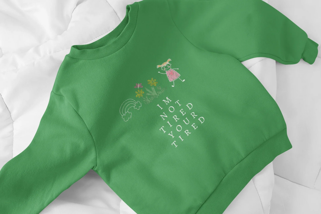 Kelly green kids sweatshirt close-up with character graphic and 'I'm Not Tired, You're Tired'