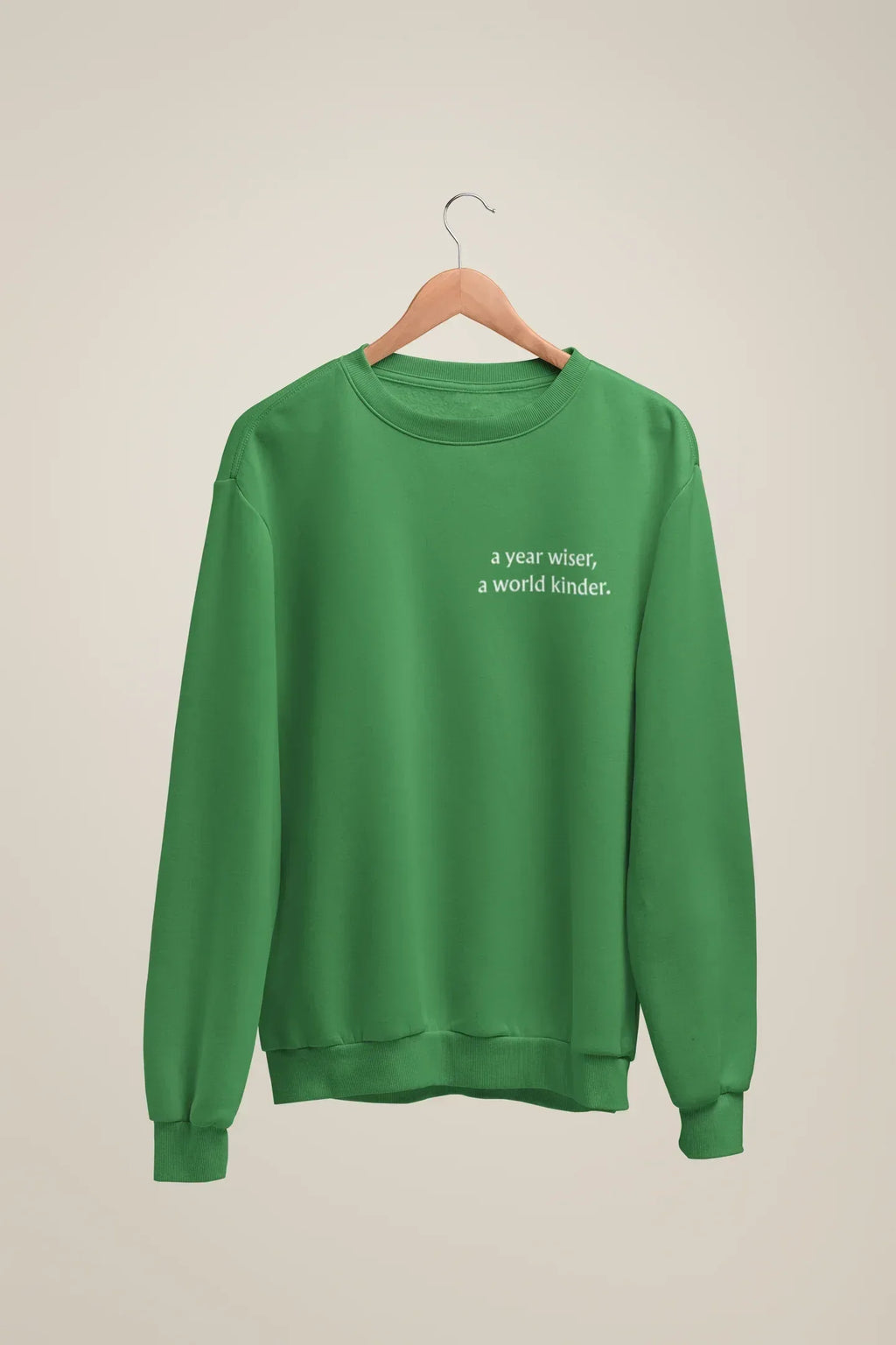 Green crewneck sweatshirt with 'a year wiser, a world kinder.' print