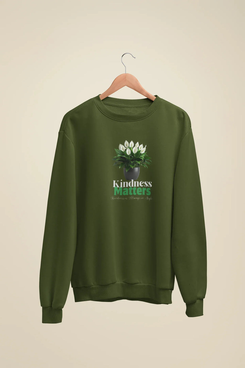 Olive green crewneck sweatshirt with tree graphic and “Kindness Matters” text on front