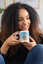 Dog-themed ceramic mug with blue “JUST LIVING” text held near face