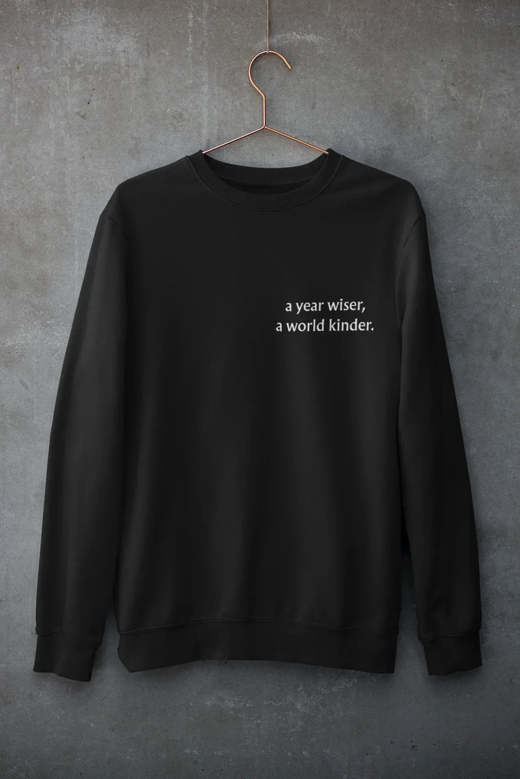 Black crewneck sweatshirt with 'a year wiser, a world kinder.' print