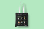 Black tote bag with white handles and plant collage artwork on the front panel.