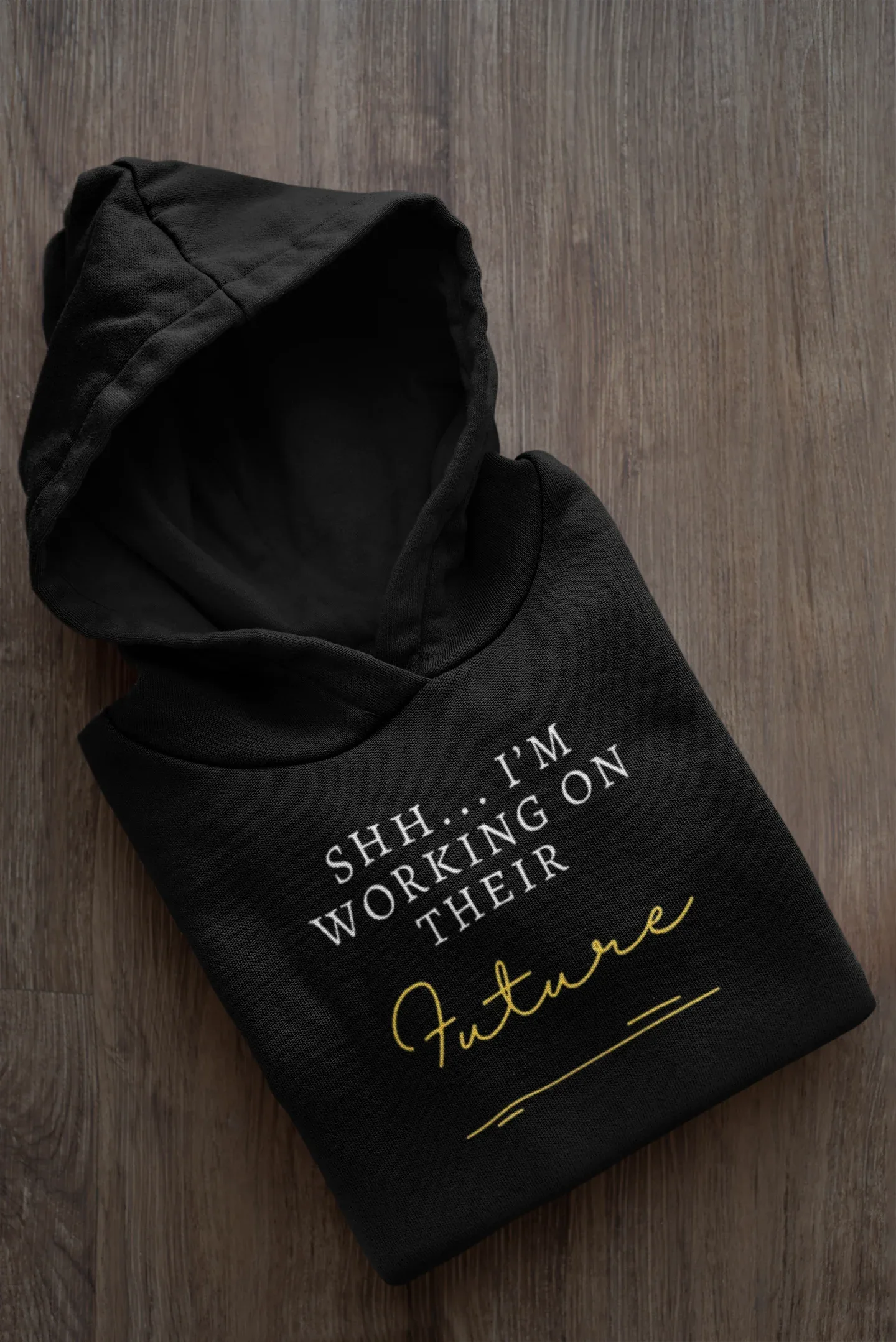 Black hooded sweatshirt, folded, with 'Future' script and 'I'm Working on Their' text