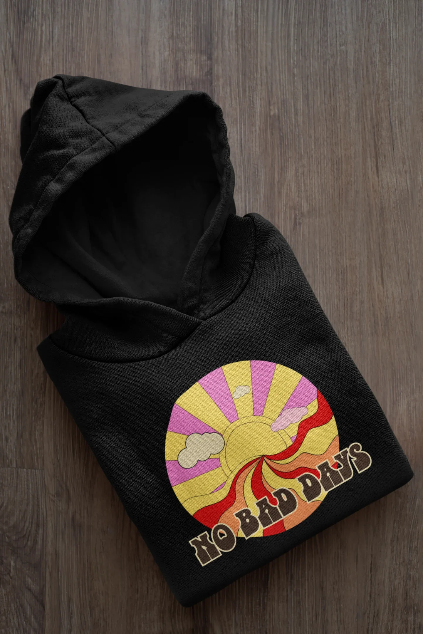 Folded black unisex hooded sweatshirt with colorful sun graphic on chest