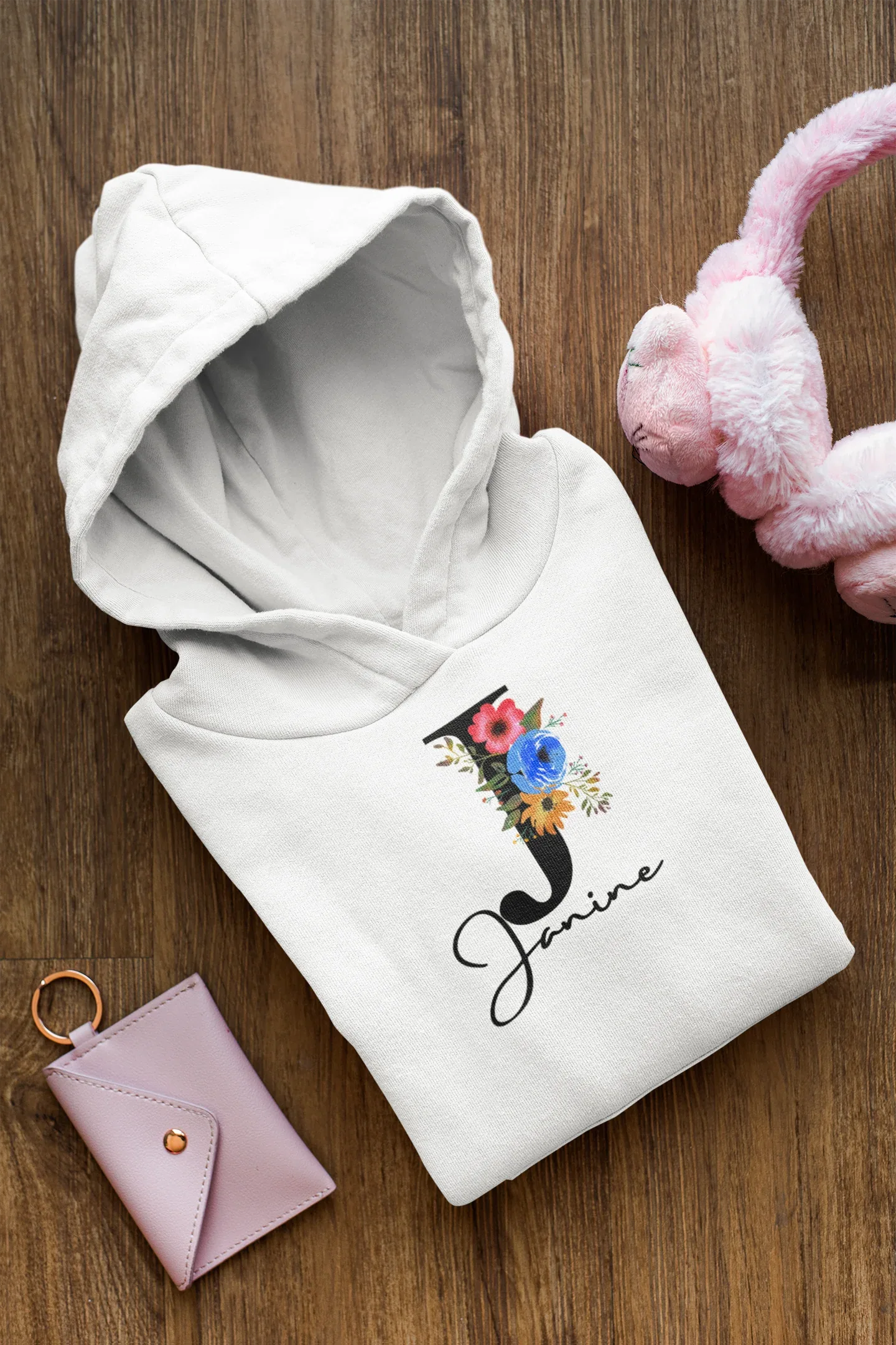Kids arctic white hoodie, folded, with floral cat and script name graphic on chest
