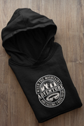Black pullover hoodie with hood and circular “Adventure” graphic on the front.