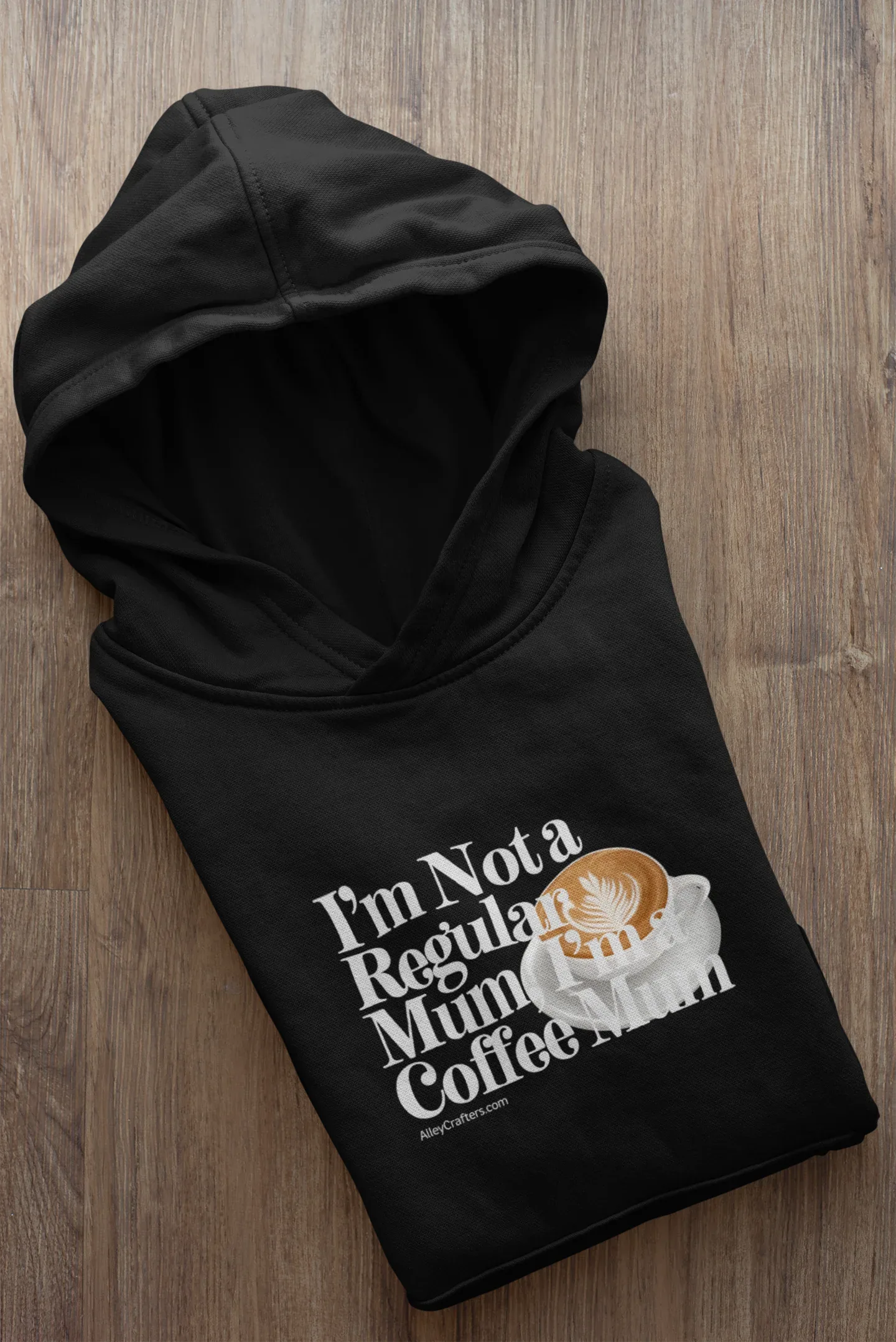 Black hoodie sweatshirt folded flat with front “Not a Regular Mum, Coffee Mum” print