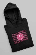 Black hooded sweatshirt with pink birthday smiley graphic and 'It's my birthday' text