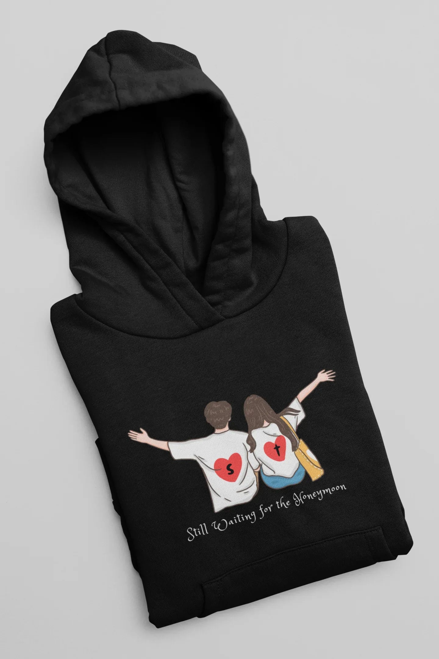 Black hoodie with hood up and couple heart graphic across the front.
