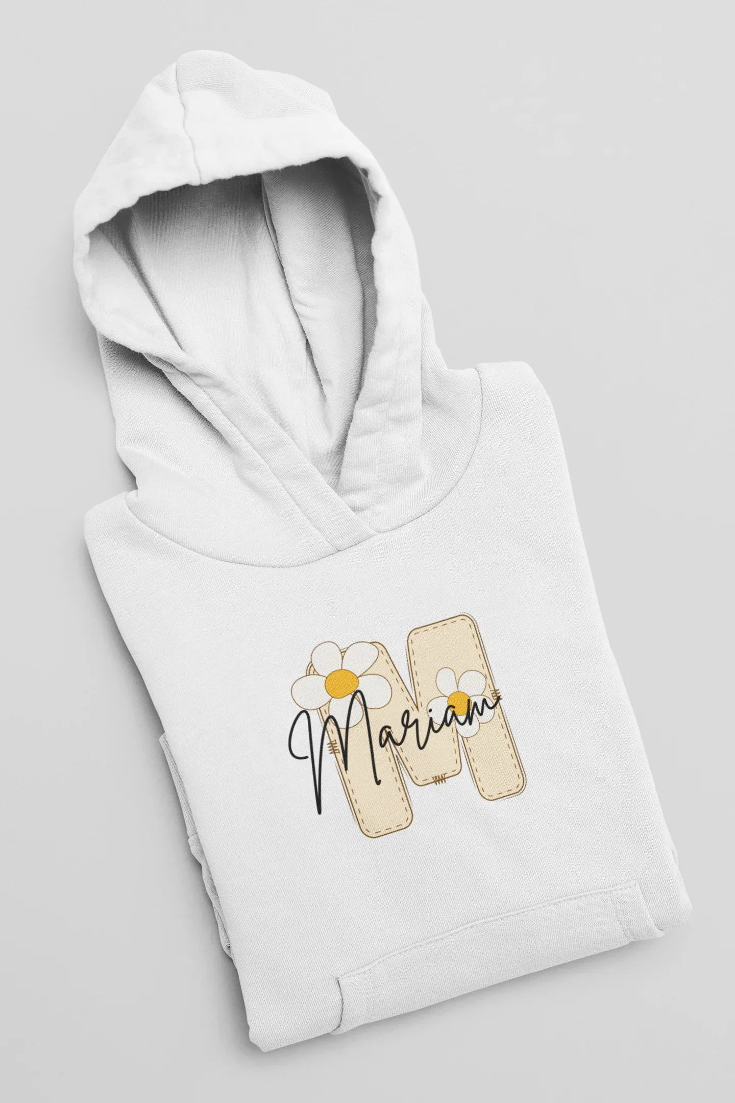 Kids white hoodie close-up, hooded neckline and front floral name print with beige tags