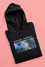 Black unisex hoodie lying flat, 'GOOD VIBES' graphic across chest