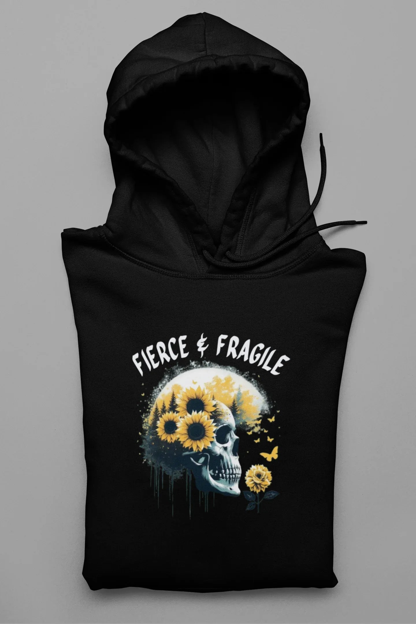 Black hooded sweatshirt laid flat with front graphic skull and flower design, drawstring hood and pocket.