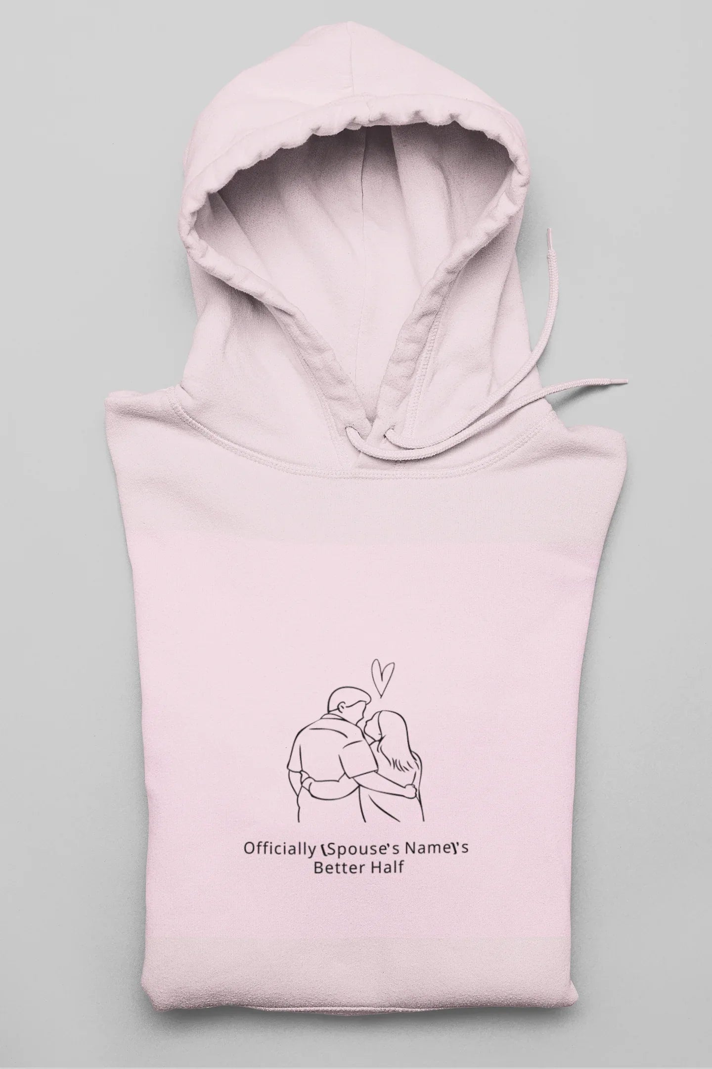 Light pink hooded sweatshirt folded with front couple graphic and drawstring hood