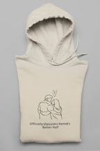 Cream hooded sweatshirt folded with front couple graphic and drawstring hood
