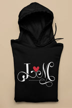 Black hoodie with heart monogram graphic on front, kangaroo pocket, drawstring hood