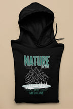 Black pullover hoodie with green “NATURE” and mountain “Best Medicine” graphic.