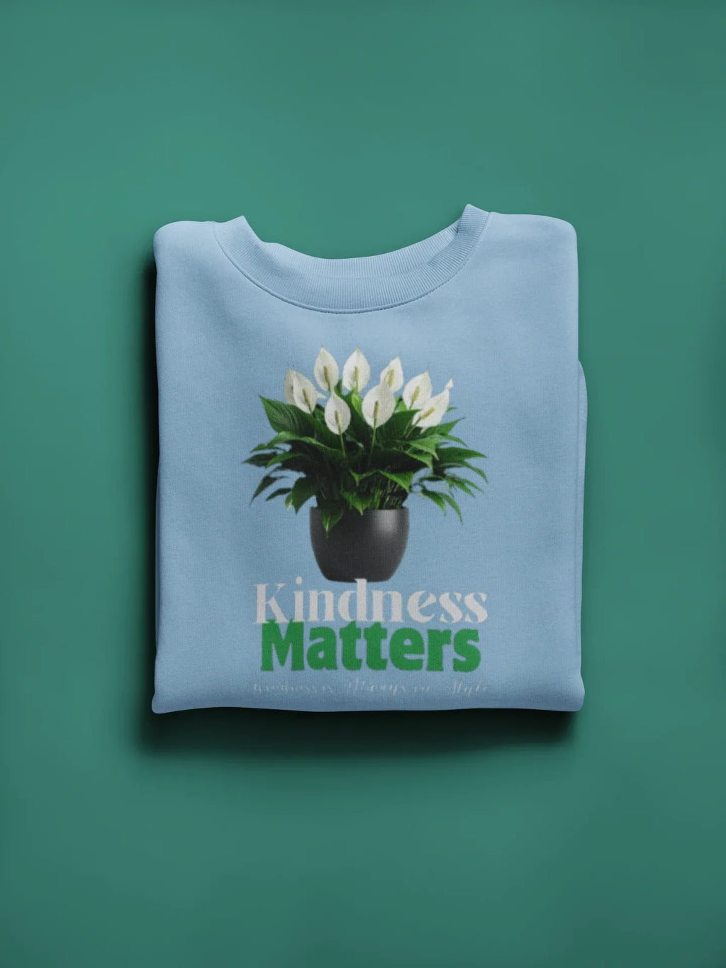 Light blue crewneck sweatshirt with tree graphic and “Kindness Matters” text on chest