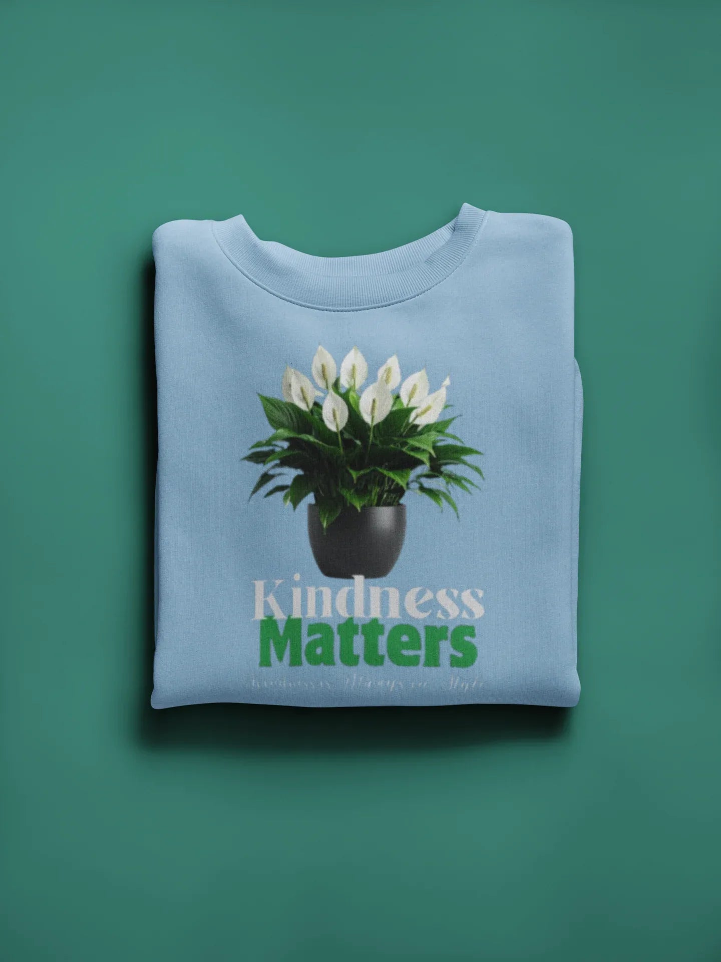 Light blue crewneck sweatshirt with tree graphic and “Kindness Matters” text on chest