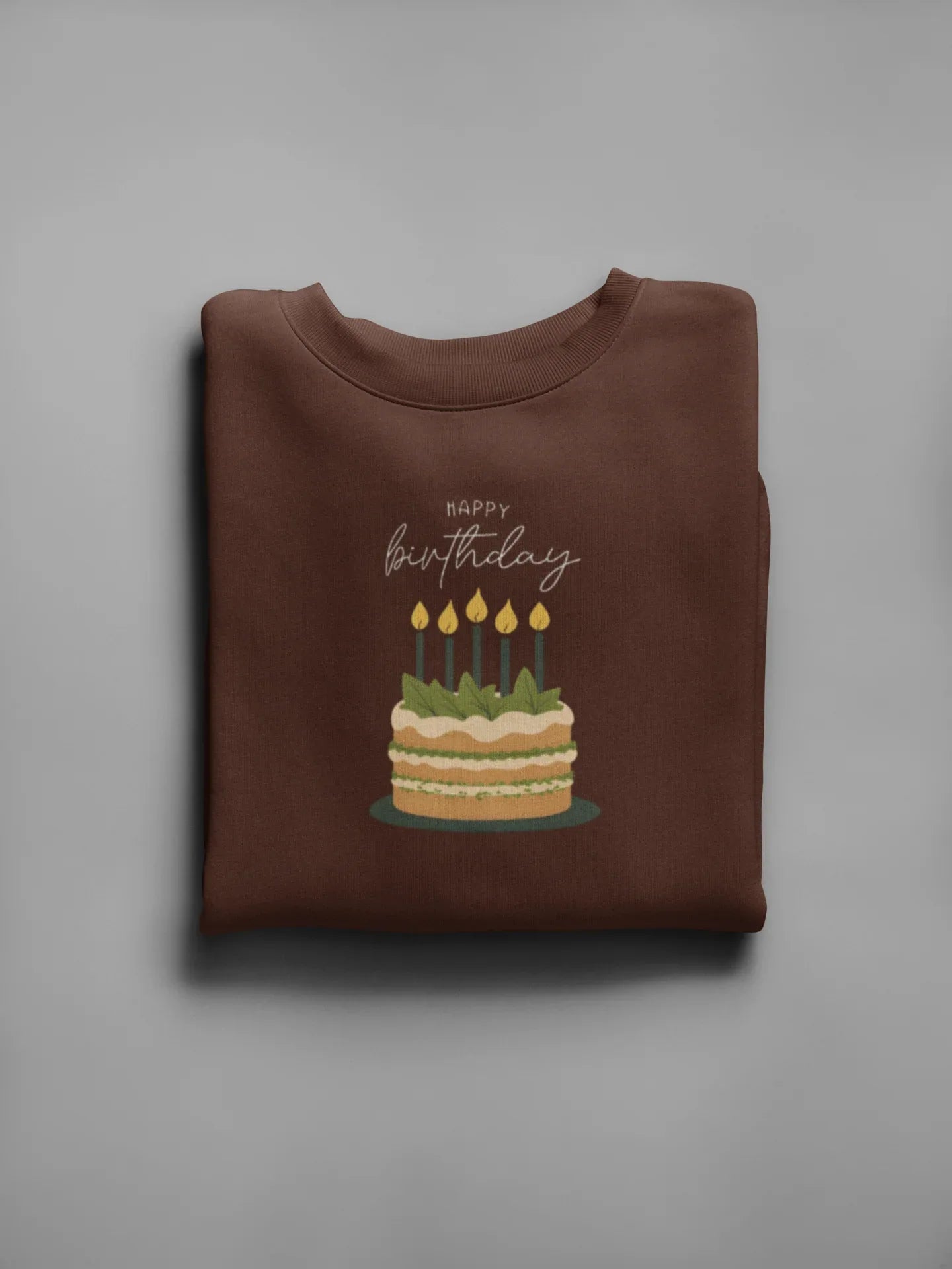 Brown birthday cake sweatshirt with front "Happy birthday" and lit candle cake graphic.