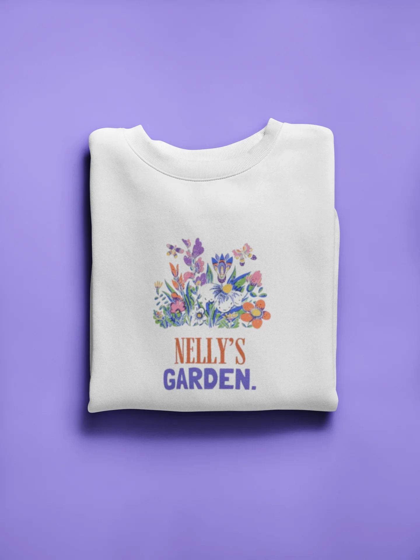 White crewneck sweatshirt with floral crest and 'Nelly's Garden' print.