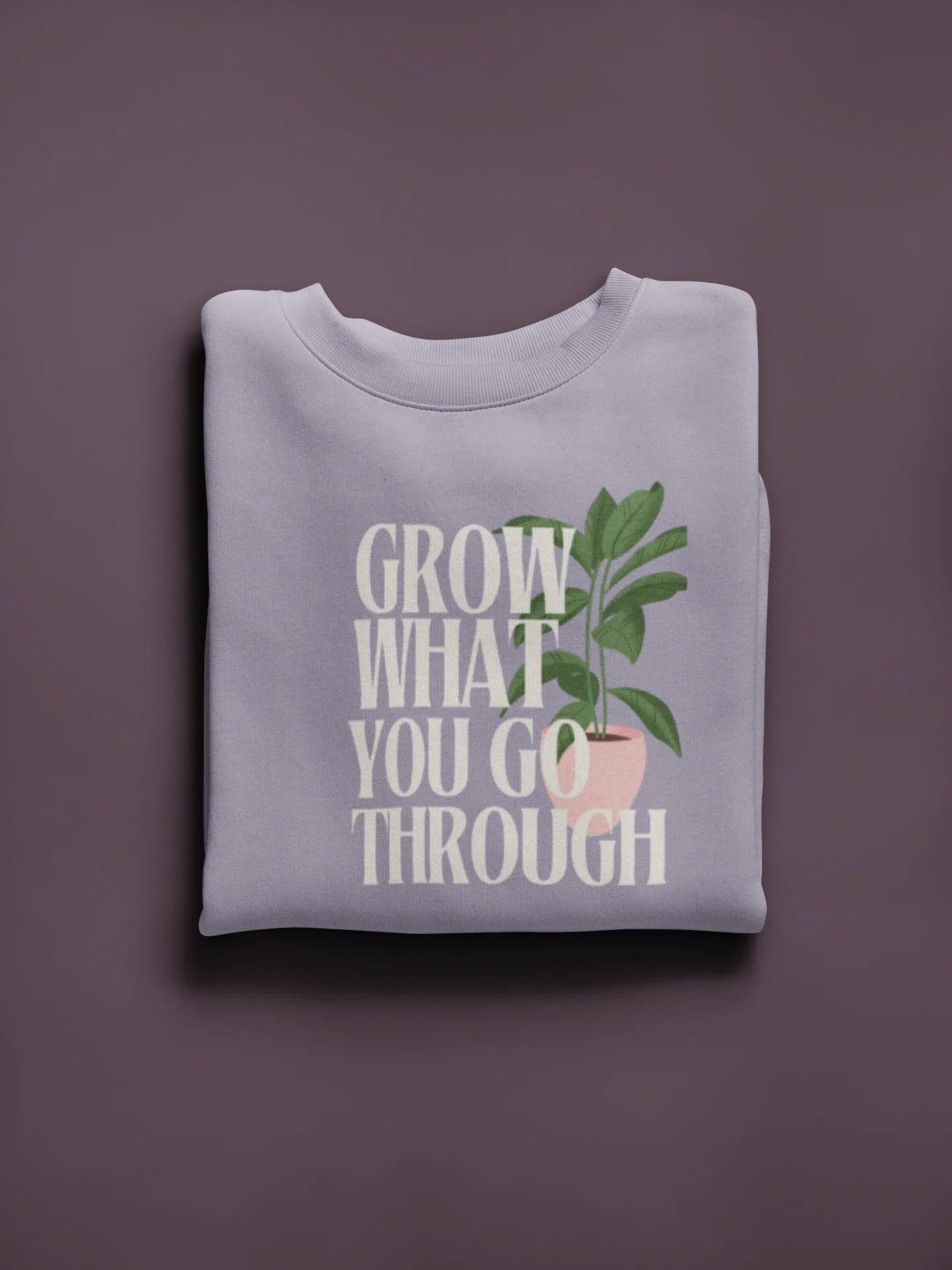 White crewneck sweatshirt with “Grow What You Go Through” graphic and green leaf