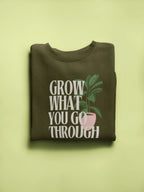 Dark olive sweatshirt with “Grow What You Go Through” text and leaf graphic