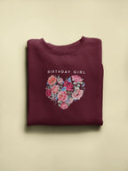 Maroon crewneck sweatshirt with “Birthday Girl” text and floral heart graphic