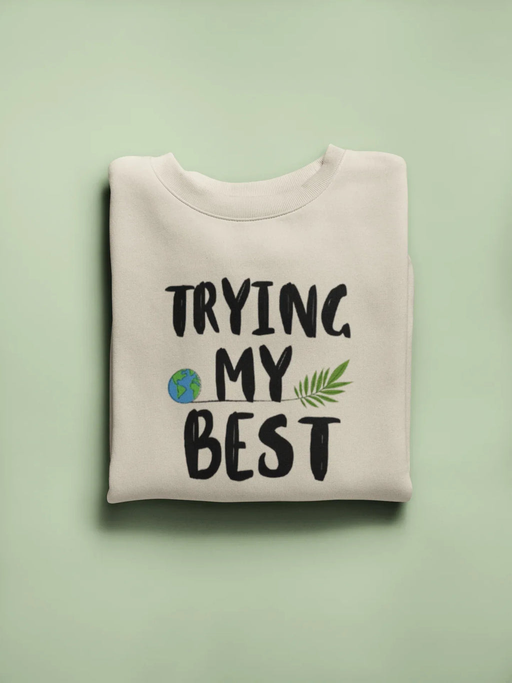 Light cream crewneck sweatshirt with 'TRYING MY BEST' graphic text and leaf icons