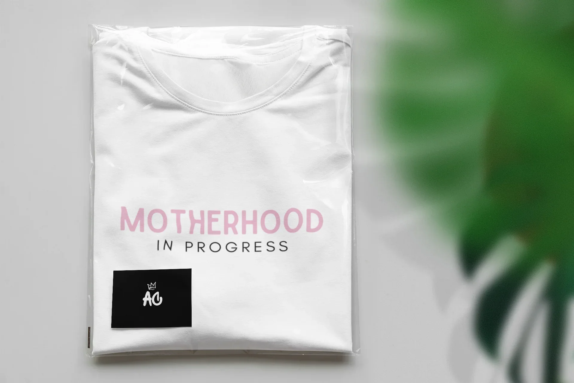 Maternity heavy cotton tee in white with pink “Motherhood in Progress” logo print