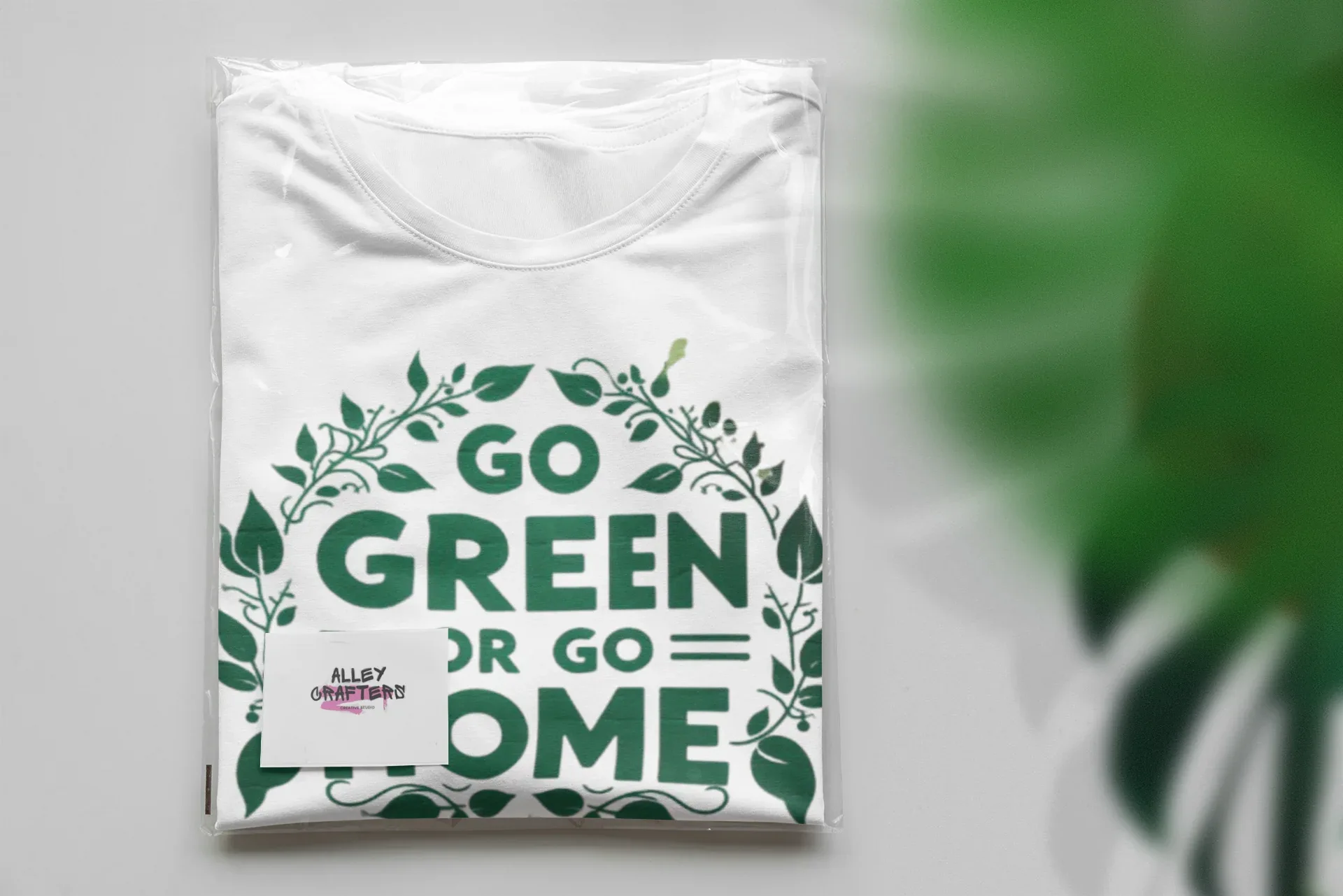 White unisex T-shirt folded with chest graphic print reading "GO GREEN OR GO HOME"
