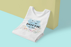 Folded white T-shirt, blue birds and floral name/year graphic.
