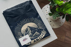 Navy short-sleeve T-shirt with mountain sunrise “RISE ABOVE” graphic